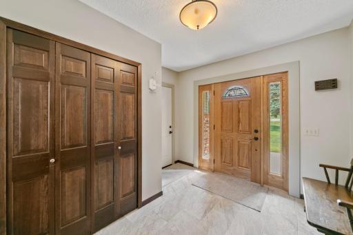 Newer front door and newer heated tile flooring in the entry