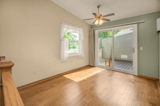 Spacious dining area has deck access and is adjacent to the kitchen. Ceiling fan and windows offer great light and airflow.
