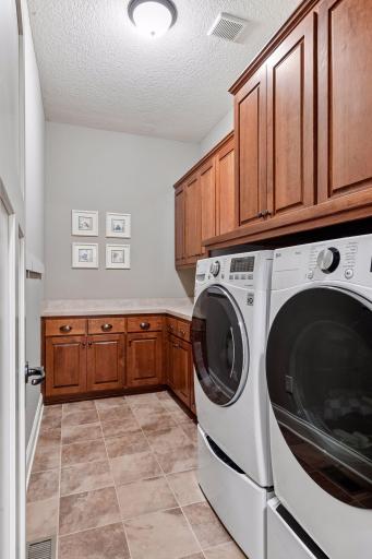 Convenient main-level laundry with generous cabinetry and utility sink.