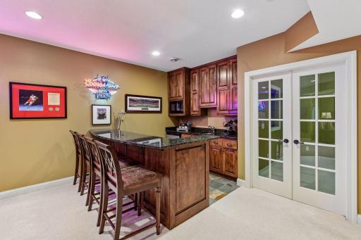 Custom wet bar provides generous seating, cabinetry and entertaining space.