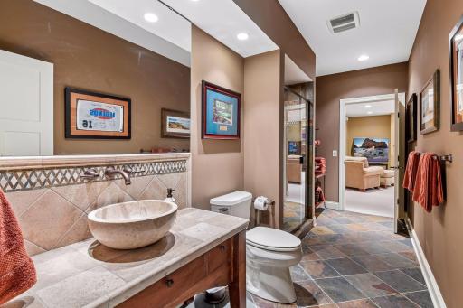 Stylish 3/4 lower-level bath features a distinctive vessel sink and tiled flooring.