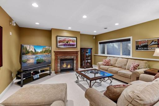 Inviting lower-level family room centered around a cozy gas fireplace.