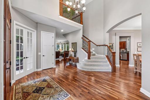 Welcoming two-story foyer showcases rich walnut hardwood floors.