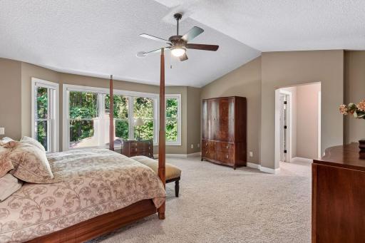 Serene primary suite enjoys vaulted ceilings and peaceful wooded views.
