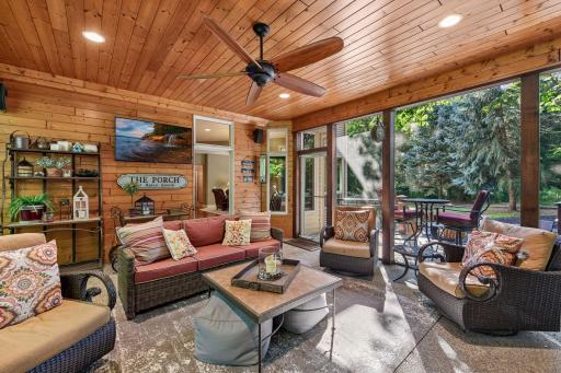 The three-season porch creates an inviting retreat surrounded by nature.