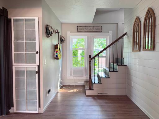 A look at the hallway between the living room, dining room, kitchen, and stairs.