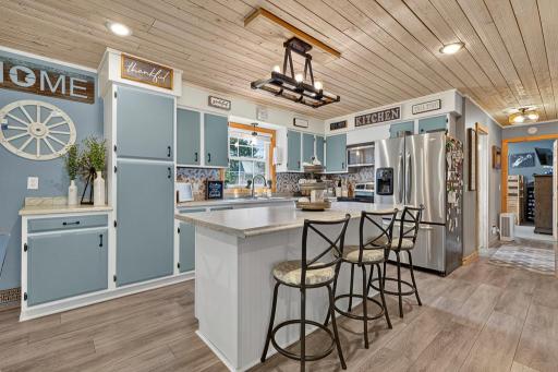 Ample kitchen space with a center island and a window over the kitchen sink overlooking the backyard.