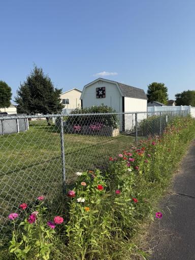 The yard features six raised garden beds and beautiful flowers!