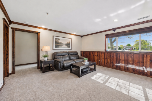 Plenty of room to relax, play, or entertain downstairs. Ceiling molding adds a finished look. Accessories and end table are visually staged.