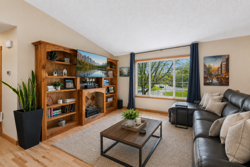 An abundance of windows fills every room with sunshine. Real wood flooring is an unexpected bonus in a new home like this! Rug and coffee sample are virtually staged.
