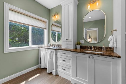 Primary ensuite bathroom featuring accessible dual vanities, including one roll-under sink for added accessibility.