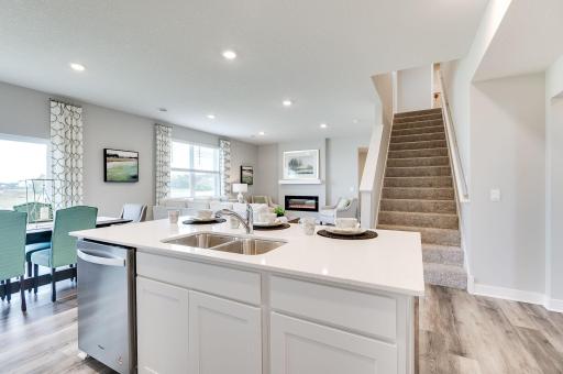 Main floor has beautiful sight lines from the kitchen to the rest of the home making it easy to move about and giving the home a bright airy feel. Model picture shown. Colors and finishes may vary.