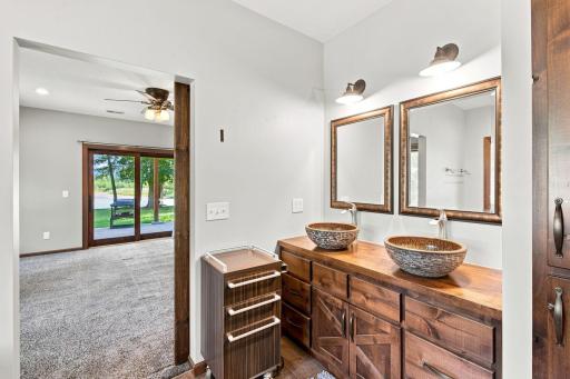 Primary en suite featuring dual sinks, jacuzzi tub, and tiled walk in shower