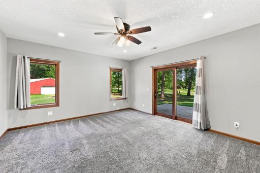 Main floor primary bedroom w/ walkout to patio overlooking pond