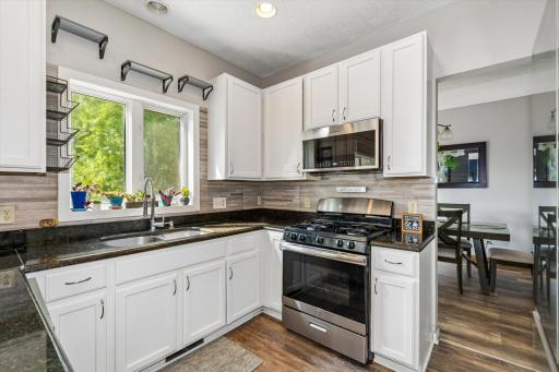 The bright and cheerful kitchen is a chef's dream, complete with granite countertops, newer stainless steel appliances, abundant cabinetry, and plenty of workspace for preparing meals and entertaining guests.