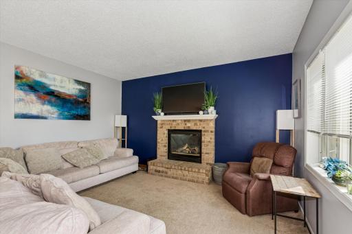 The welcoming main level features an open and functional floor plan with two spacious gathering areas, including a cozy living room centered around a beautiful fireplace.