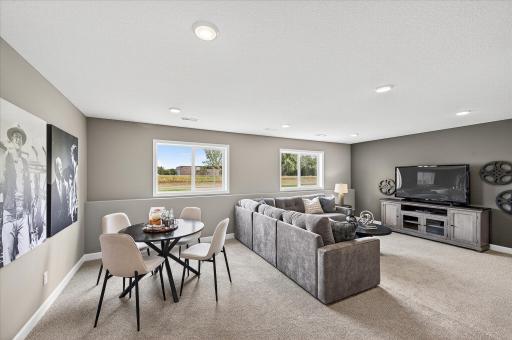 Finished lower level family room - photos are of a staged model home of the same floorplan. Selections and colors may differ.