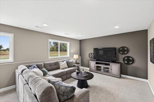 Finished lower level family room - photos are of a staged model home of the same floorplan. Selections and colors may differ.