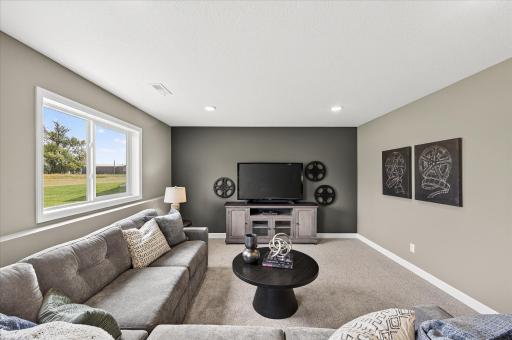 Finished lower level family room - photos are of a staged model home of the same floorplan. Selections and colors may differ.