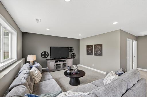Finished lower level family room - photos are of a staged model home of the same floorplan. Selections and colors may differ.
