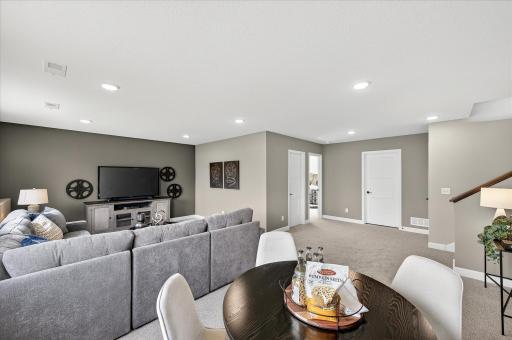Finished lower level family room - photos are of a staged model home of the same floorplan. Selections and colors may differ.