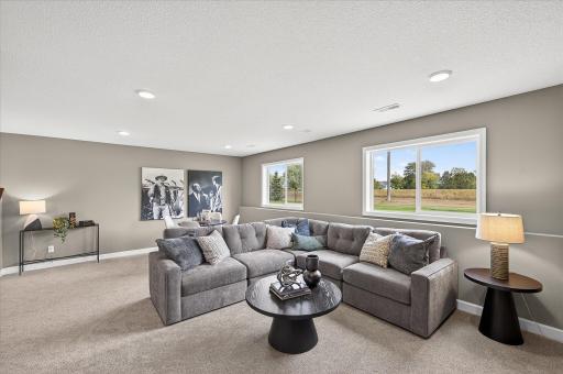 Finished lower level family room - photos are of a staged model home of the same floorplan. Selections and colors may differ.