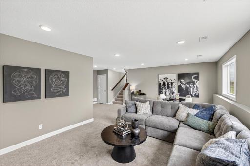 Finished lower level family room - photos are of a staged model home of the same floorplan. Selections and colors may differ.