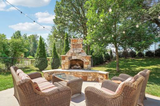 Welcome to your backyard oasis featuring a fenced yard and beautiful built-in outdoor fireplace.