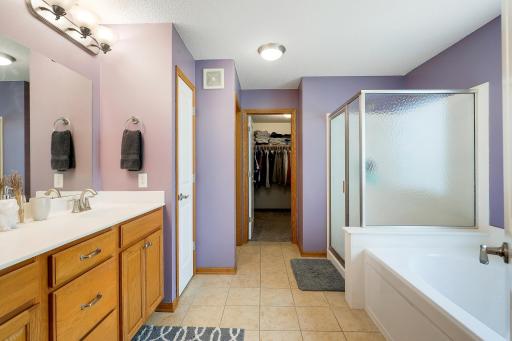 The well-appointed primary ensuite includes dual vanities, a luxurious soaking tub, a separate shower, and a private water closet for added comfort and convenience.