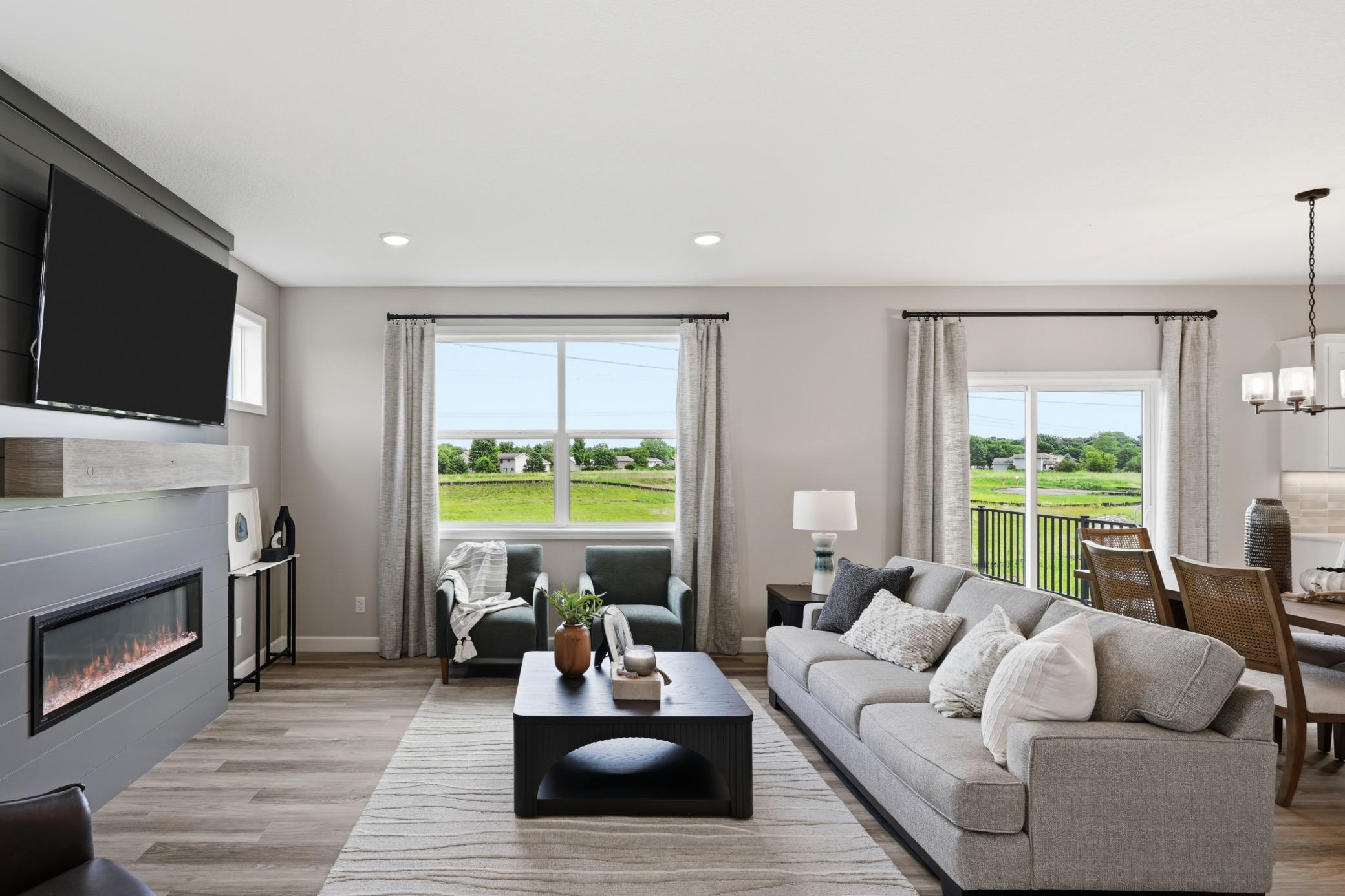 Living room with tons of natural light - photos of a staged, completed model, of the same floorplan for illustrative purposes.
