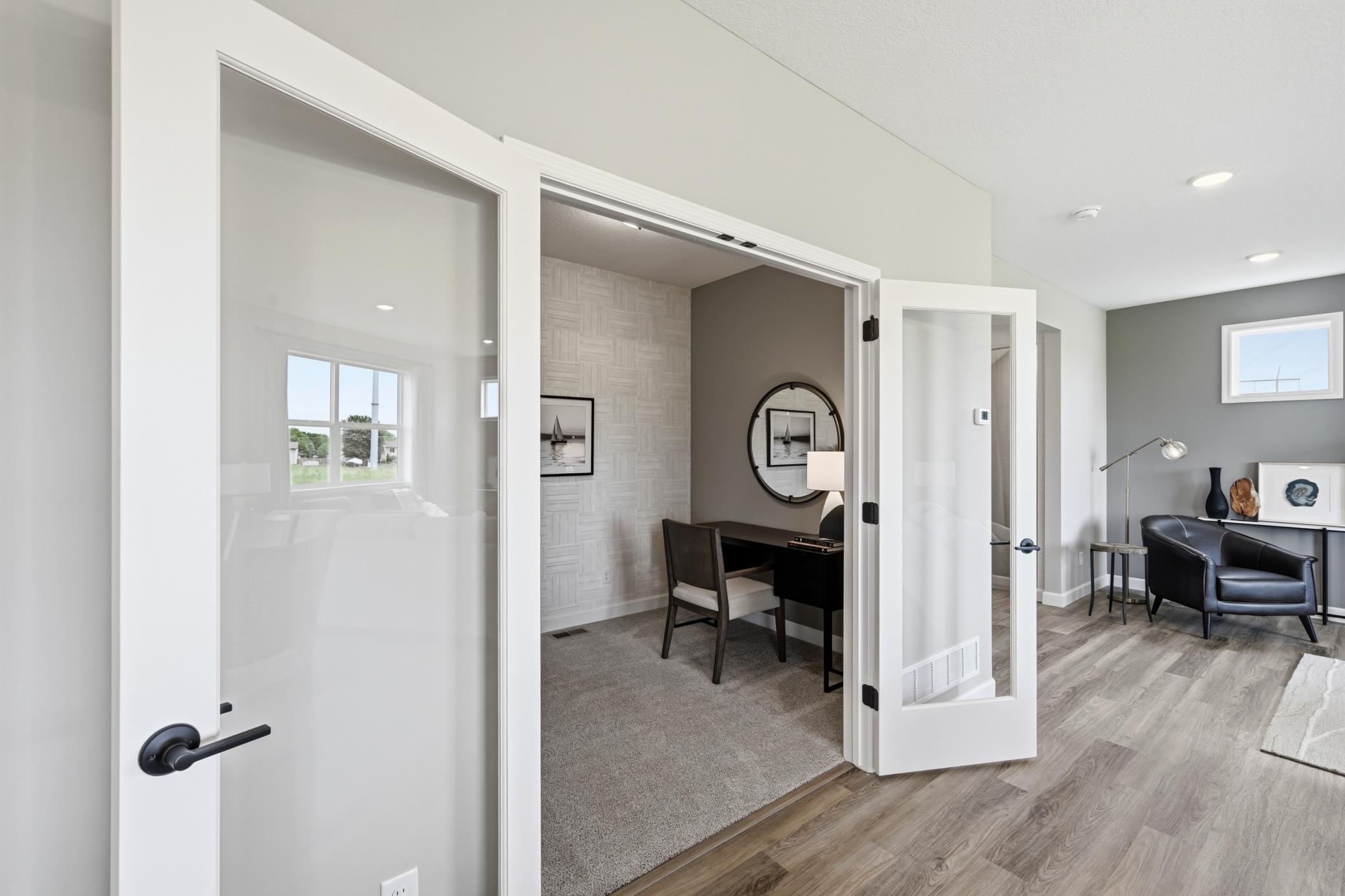 Main floor office with french doors - photos of a staged, completed model, of the same floorplan for illustrative purposes.