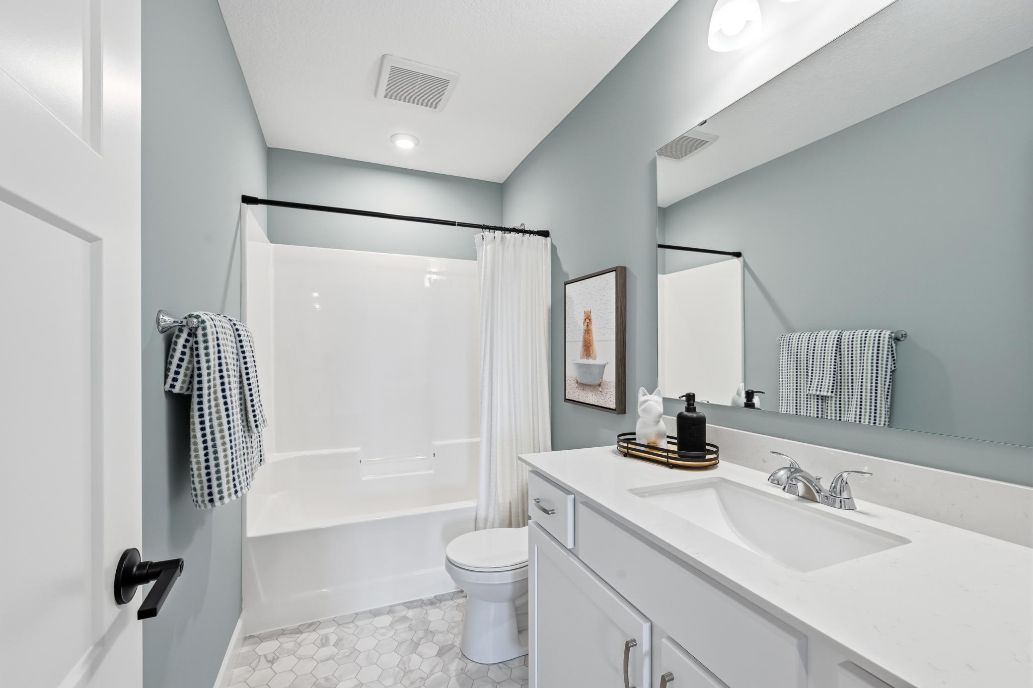 Main floor full bath - photos of a staged, completed model, of the same floorplan for illustrative purposes.