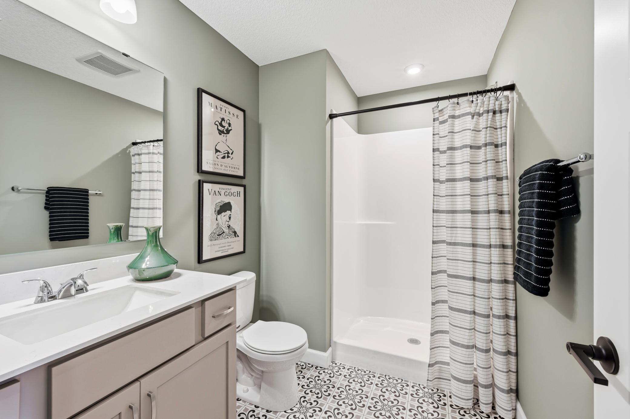 Lower level bathroom - photos of a staged, completed model, of the same floorplan for illustrative purposes.