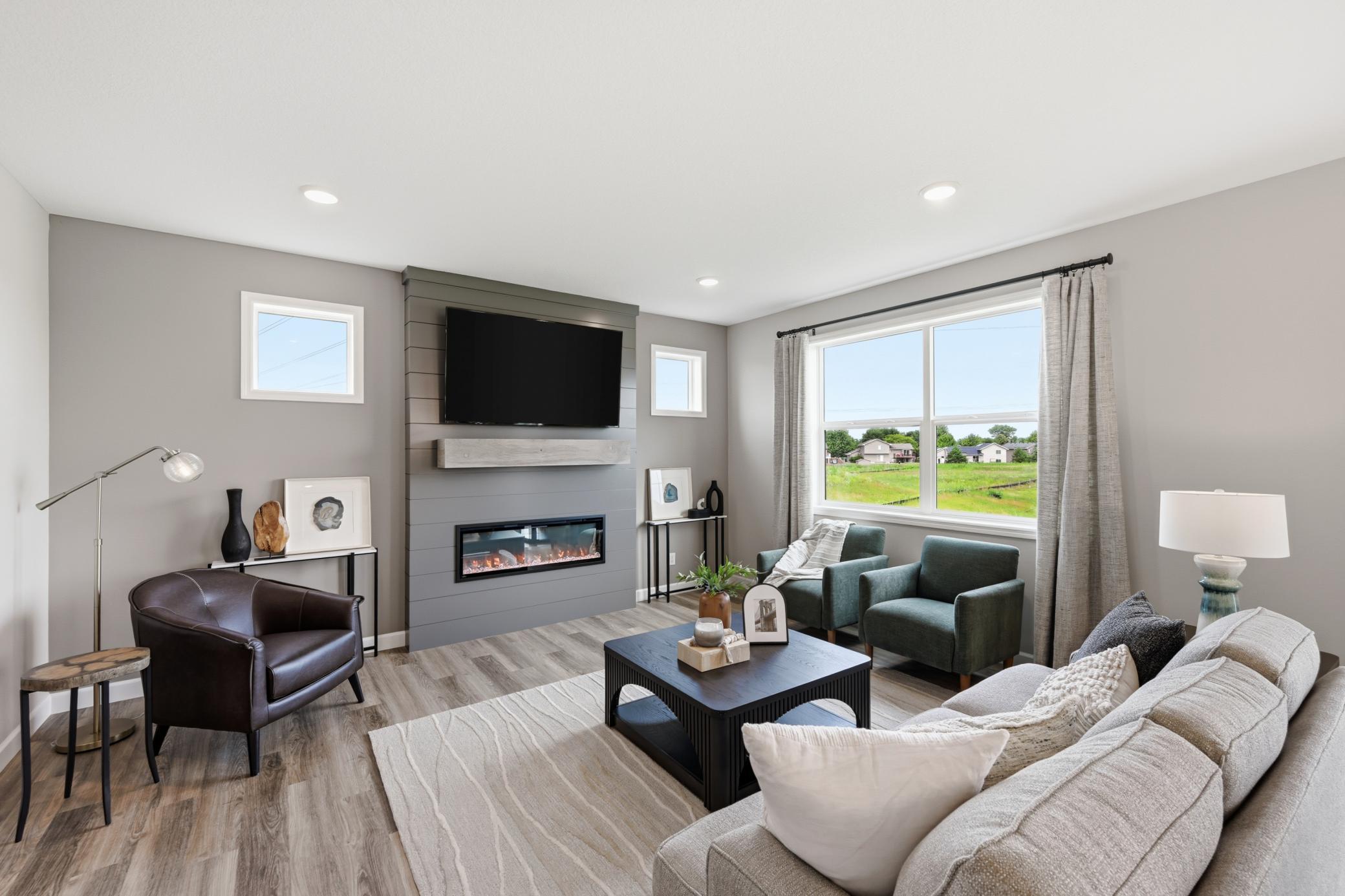 Living room with cozy fireplace - photos of a staged, completed model, of the same floorplan for illustrative purposes.
