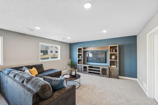 Finished lower level family room - photo is of a staged model home of the same floorplan. Selections and colors may differ.