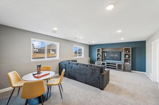 Finished lower level family room - photo is of a staged model home of the same floorplan. Selections and colors may differ.
