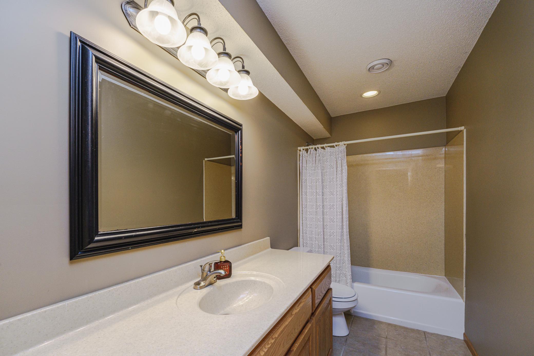 This FULL lower level bath with tile flooring provides options for guests.
