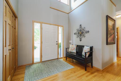 The spacious entry foyer has hardwood flooring and is brightened by full-view sidelight windows.