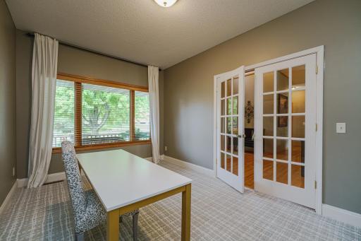 A large picture window in the office overlooks the porch. The patterned carpet is new as of 2022.