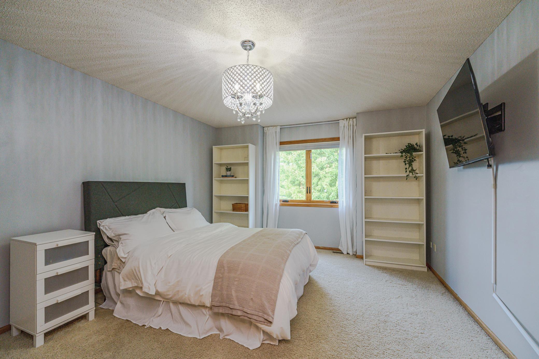 This is one of three upper level bedrooms. This room has bookcases and a beautiful chandelier.