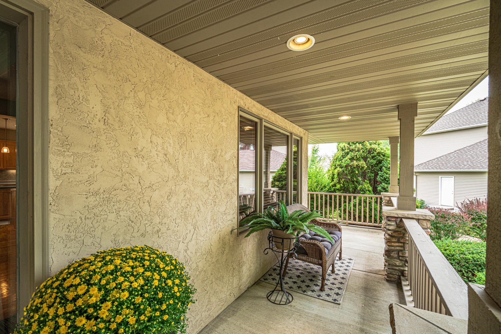 This wraparound front porch is covered, lit, and roomy enough for your furnishings.