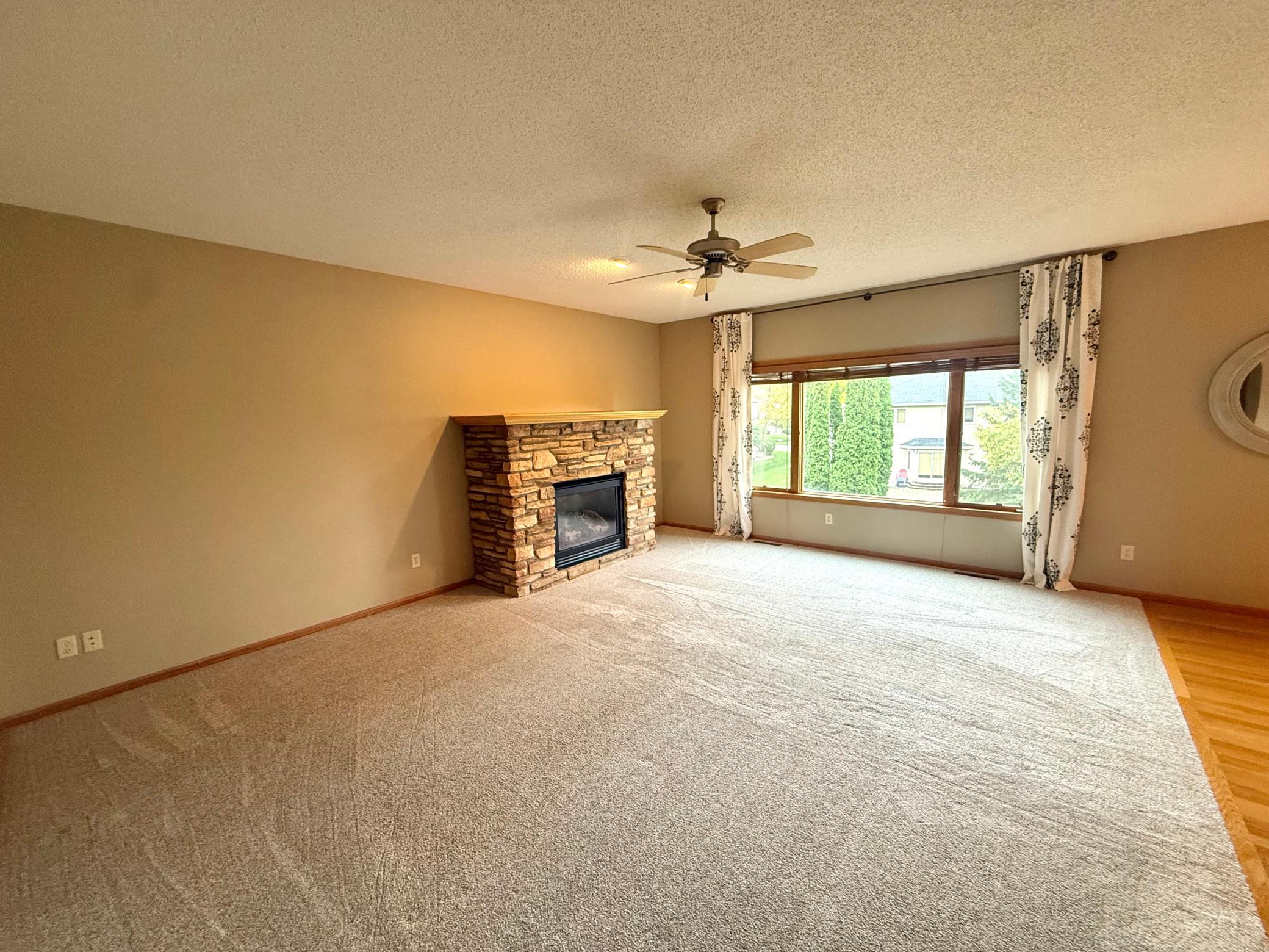 The family room features 9-foot ceilings with a fan, a stone (gas) fireplace, recessed lighting, oversized windows and NEW CARPET as of 2022.