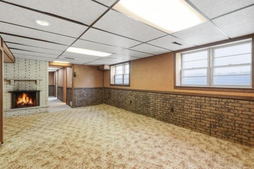 Lower Level ~ Family Room features gas fireplace with brick surround