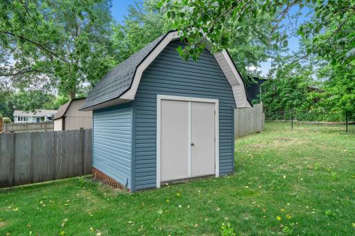 2 story storage shed in with a workbench and industrial shelving units.