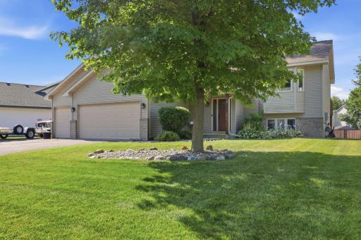 Charming split-level home with a spacious front yard shaded by a mature maple tree. The three-car garage, brick accents, and manicured landscaping offer great curb appeal from the street.