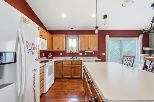 Vaulted ceilings and modern pendant lighting add character to this eat-in kitchen, complete with a sliding glass door out to the deck. A spacious center island offers extra counter space and seating for casual meals.