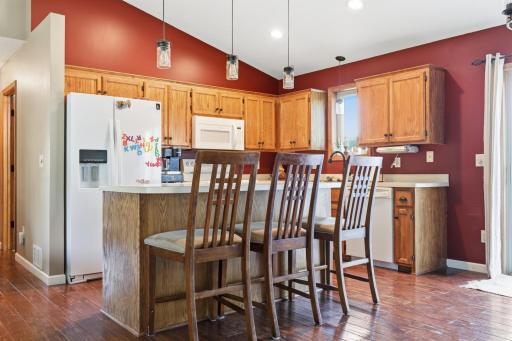 Counter-height seating at the island makes this kitchen a natural spot for quick breakfasts or homework time. Rich wood flooring and abundant cabinet storage round out this functional, user-friendly space.