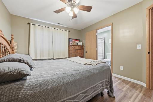 This lower-level bedroom offers direct access to its own private bathroom, adding everyday convenience. Warm wood flooring round out the comfortable, private feel.