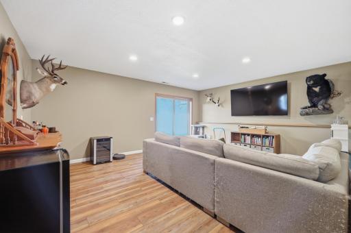 This spacious lower-level family room offers durable wood-look flooring and a sliding door out to the backyard for easy indoor-outdoor flow.