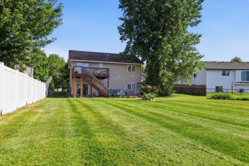 A fully fenced, spacious backyard offers privacy and plenty of room to play, relax, or entertain. The upper deck with staircase access adds convenient outdoor living space just off the main level.